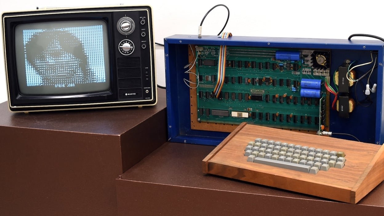 A circuit board and keyboard hooked up to an old TV with an image of Steve Jobs