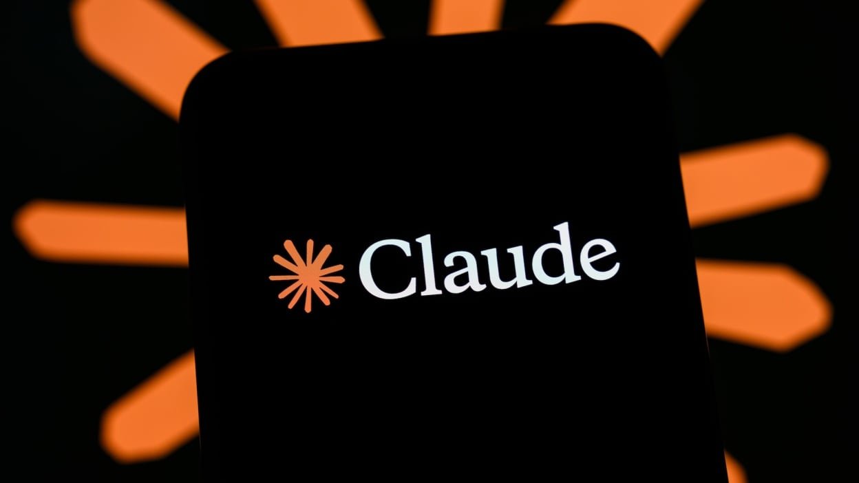 The Claude logo is displayed on a smartphone screen with the icon of the AI model in the background.