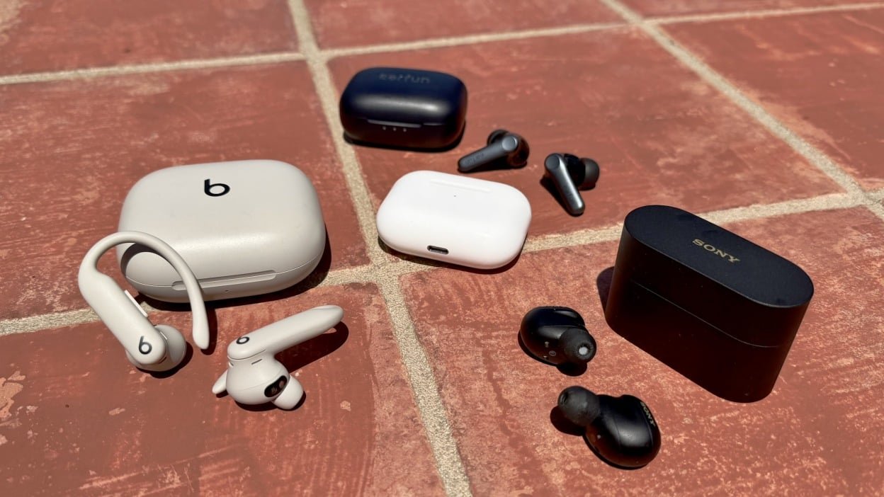three pairs of headphones around airpods max on tile outside