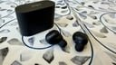 black sony wf-1000xm6 earbuds and case on blue and white mosaic tile