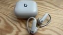 beats powerbeats pro case and earbuds on wooden table top
