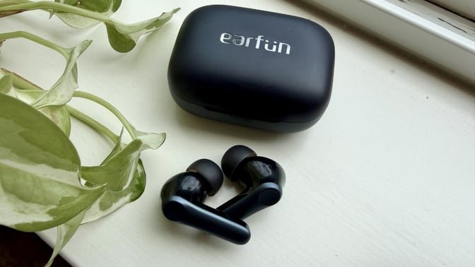 earfun air pro 4 earbuds on window sill next to plant